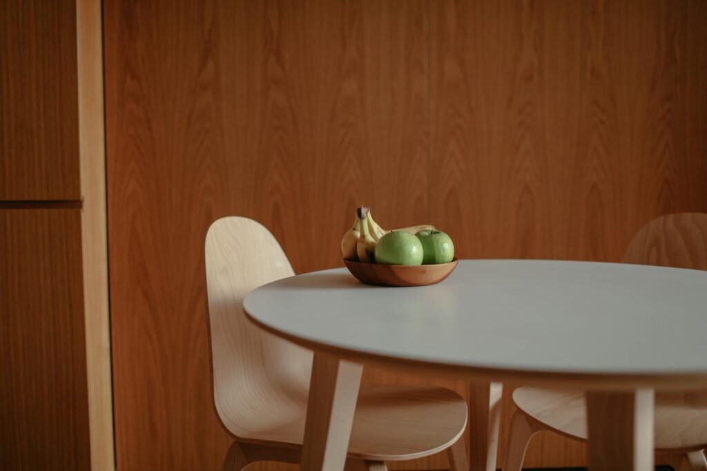 A shallow fruit bowl with apples, bananas, and clementines on a kitchen counter