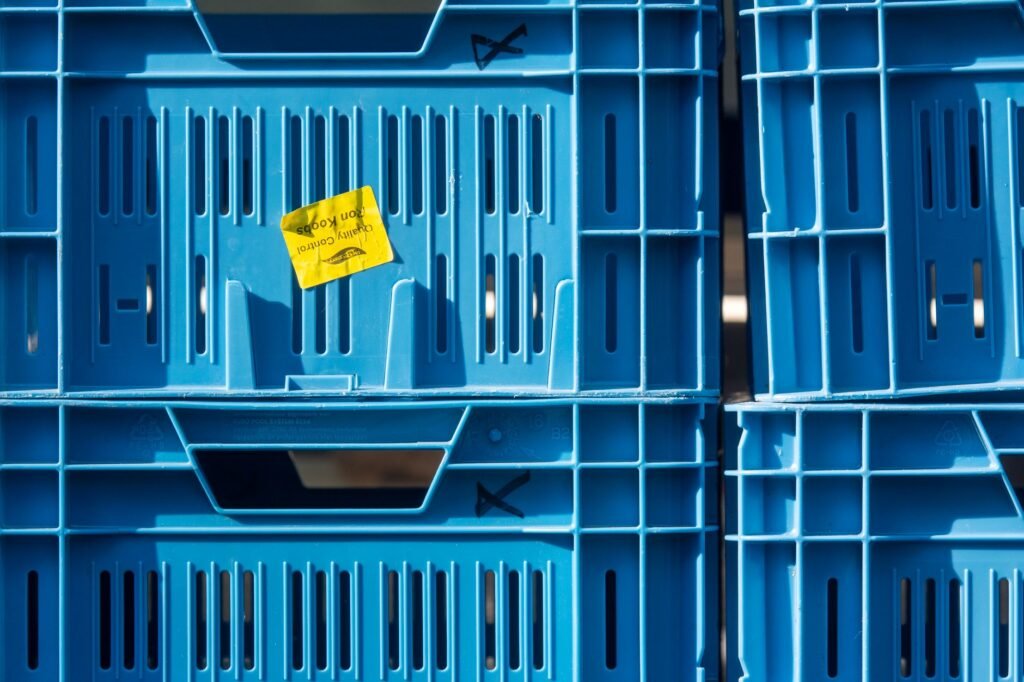Stacked food containers with date labels in a freezer drawer
